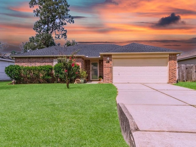 ranch-style house featuring a garage and a yard