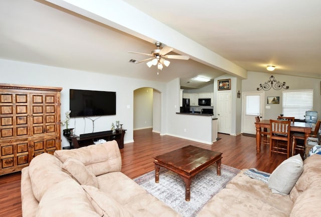 living room featuring vaulted ceiling with beams, ceiling fan, and dark wood-type flooring