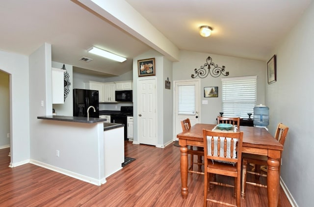 dining space with dark hardwood / wood-style flooring and vaulted ceiling