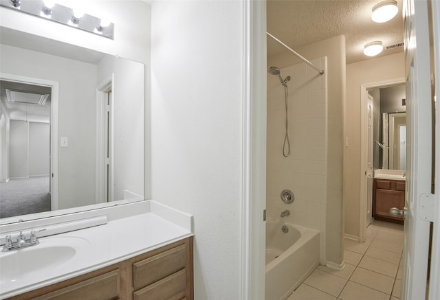 bathroom featuring tile patterned flooring, tiled shower / bath combo, a textured ceiling, and vanity