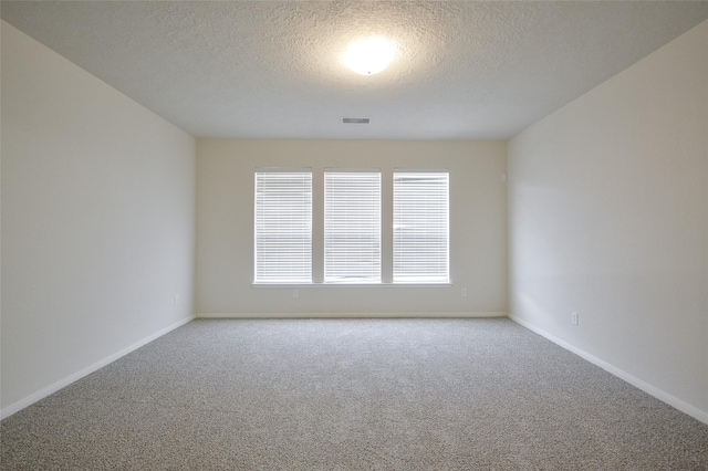 unfurnished room featuring a textured ceiling and carpet floors