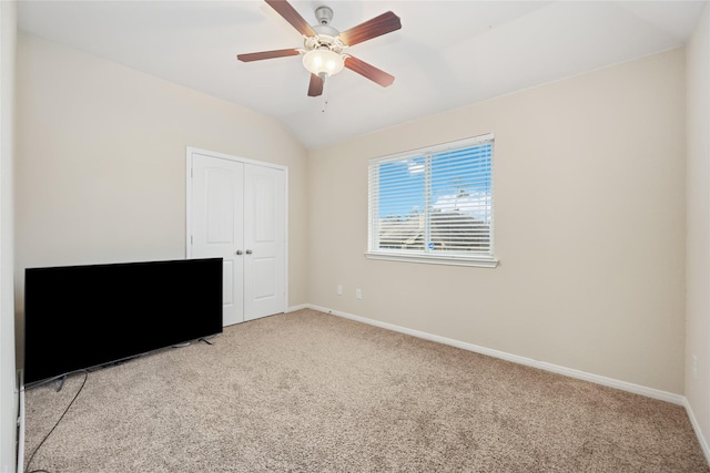 unfurnished bedroom with ceiling fan, lofted ceiling, light carpet, and a closet