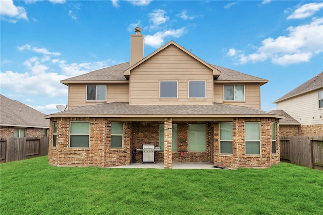 rear view of house with a patio area and a yard