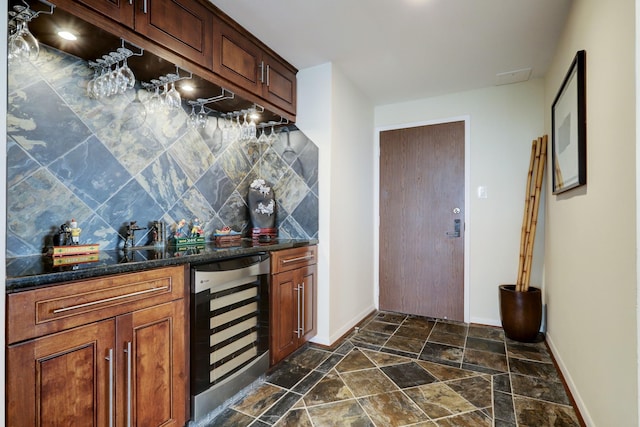 bar featuring decorative backsplash, wine cooler, and dark stone countertops