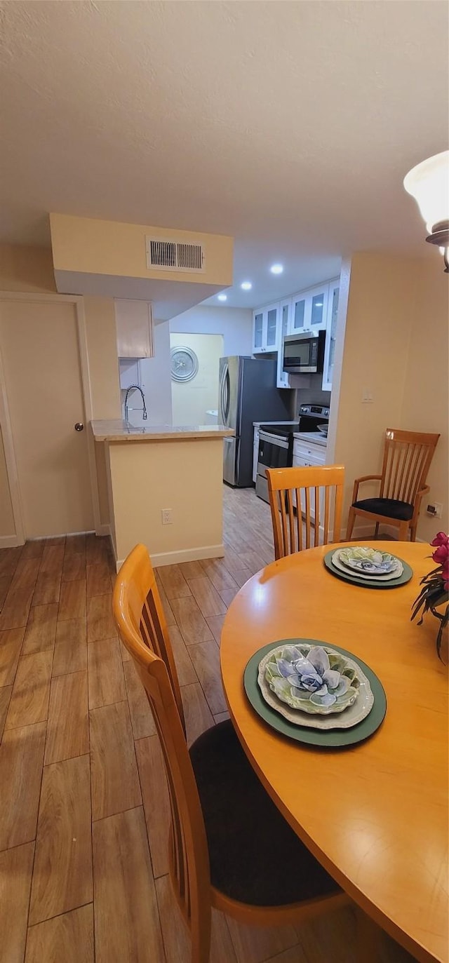 dining space featuring light hardwood / wood-style flooring and sink