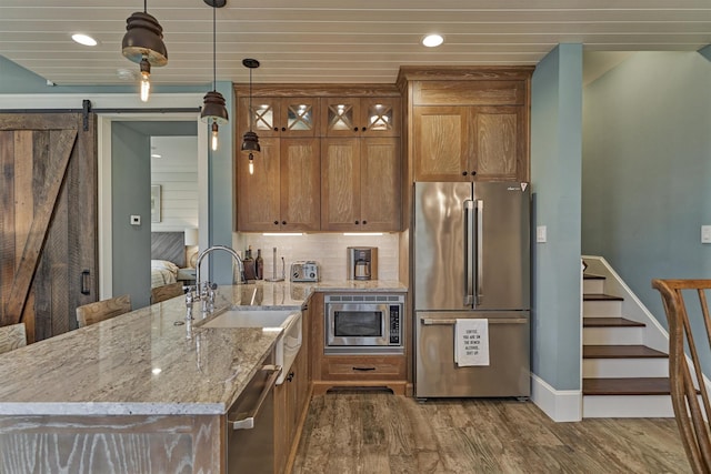26210 Bluejack National Blvd Unit 14, Montgomery, TX 77316 - kitchen with hanging light fixtures, a barn door, light hardwood / wood-style floors, wood ceiling, and appliances with stainless steel finishes