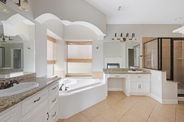 bathroom featuring tile patterned flooring, shower with separate bathtub, and vanity