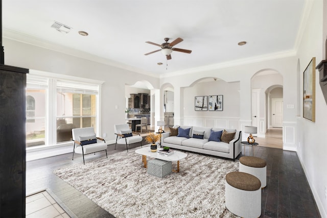 living room with crown molding, ceiling fan, and dark hardwood / wood-style floors