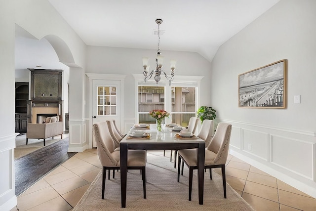 tiled dining room featuring a chandelier and lofted ceiling