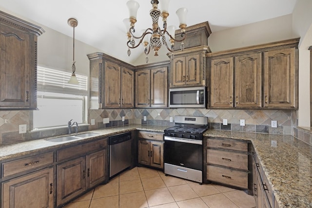 kitchen featuring light stone countertops, sink, pendant lighting, light tile patterned floors, and appliances with stainless steel finishes