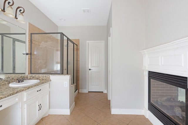 bathroom featuring tile patterned flooring, vanity, and an enclosed shower