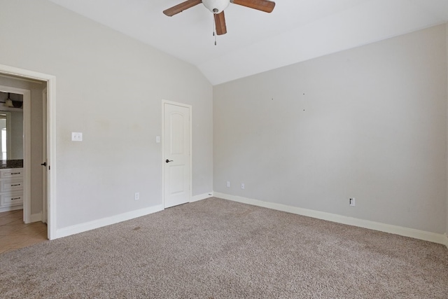 empty room with carpet floors, vaulted ceiling, and ceiling fan