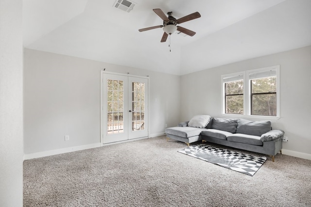 carpeted living room with ceiling fan, a healthy amount of sunlight, vaulted ceiling, and french doors