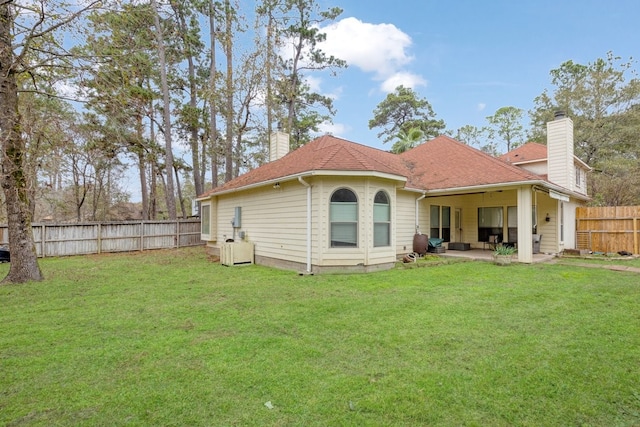 rear view of property with a yard and a patio