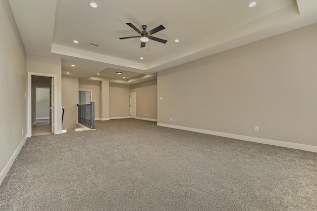 unfurnished living room featuring ceiling fan, carpet floors, and a tray ceiling