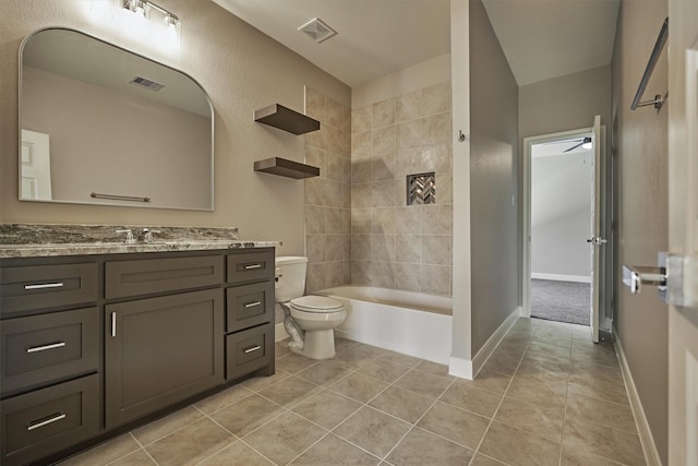 full bathroom featuring vanity, tiled shower / bath, tile patterned flooring, ceiling fan, and toilet