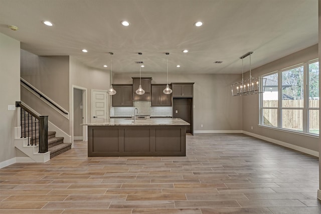 3050 Willowbend Rd, Montgomery, TX 77356 - kitchen featuring recessed lighting, light wood finished floors, a chandelier, an island with sink, and tasteful backsplash