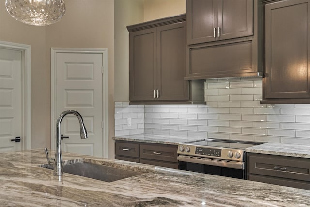 3050 Willowbend Rd, Montgomery, TX 77356 - kitchen with stainless steel electric range oven, tasteful backsplash, light stone countertops, and dark brown cabinetry