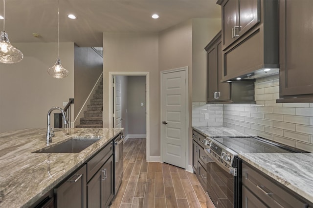 kitchen featuring appliances with stainless steel finishes, tasteful backsplash, light stone counters, and sink