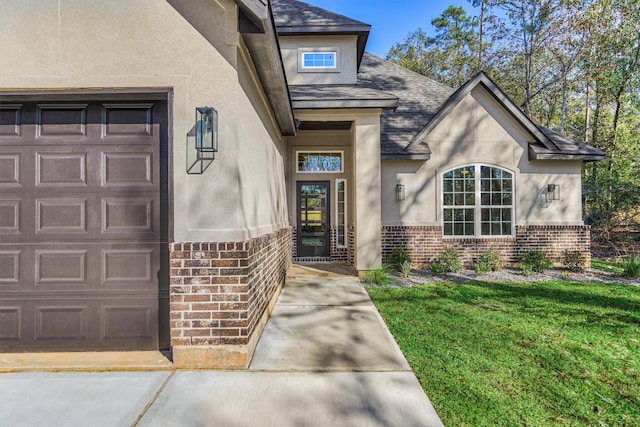 entrance to property featuring a lawn and a garage