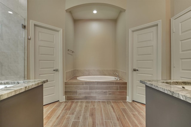 3050 Willowbend Rd, Montgomery, TX 77356 - bathroom with vanity, a bath, wood finished floors, tiled shower, and recessed lighting