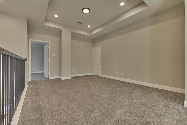 unfurnished room featuring a raised ceiling and carpet floors