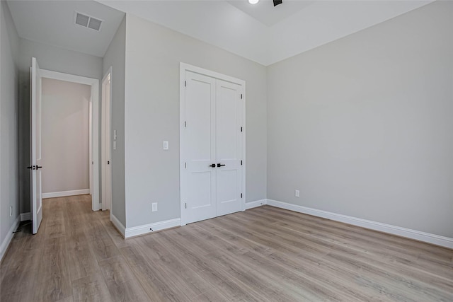 unfurnished bedroom featuring ceiling fan, a closet, and light hardwood / wood-style floors