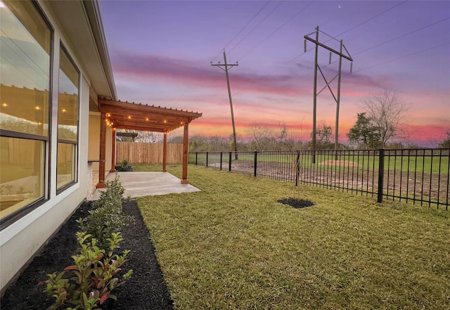 yard at dusk featuring a patio area