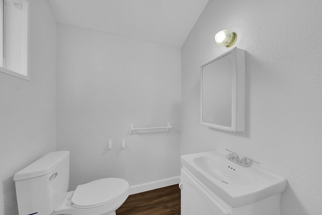 bathroom with sink, hardwood / wood-style floors, vaulted ceiling, and toilet