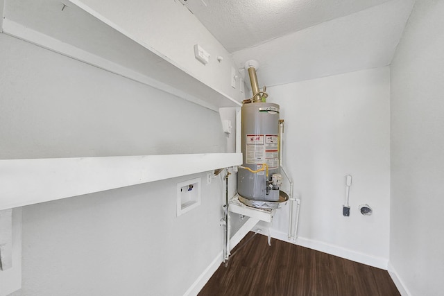 clothes washing area with a textured ceiling, dark hardwood / wood-style floors, washer hookup, and gas water heater