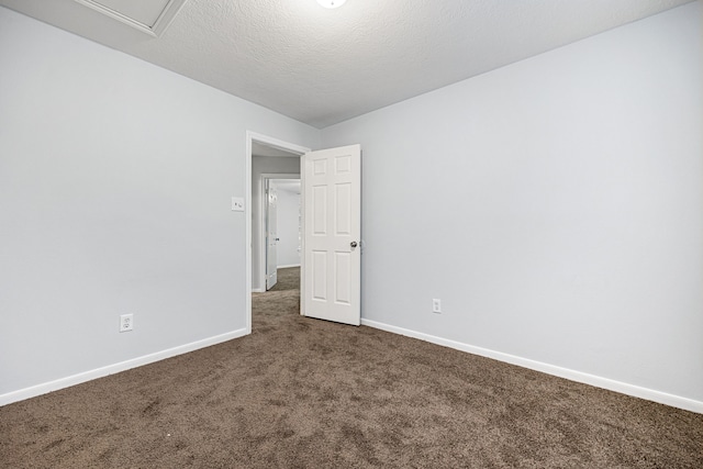 carpeted empty room featuring a textured ceiling