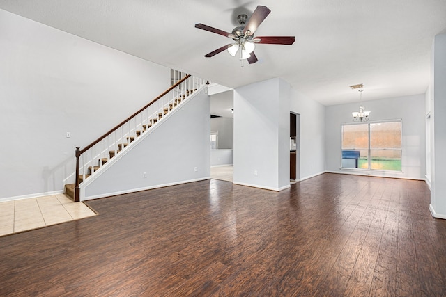 unfurnished living room featuring ceiling fan with notable chandelier and wood-type flooring