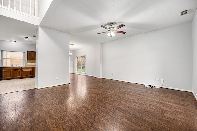 unfurnished living room with ceiling fan with notable chandelier, light hardwood / wood-style flooring, and sink