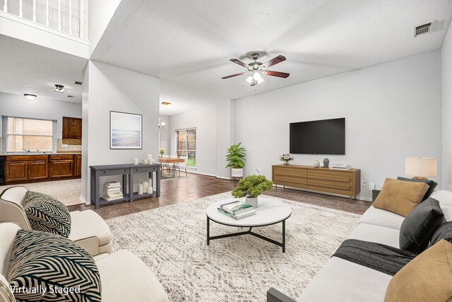 living room with ceiling fan, a healthy amount of sunlight, light hardwood / wood-style floors, and sink