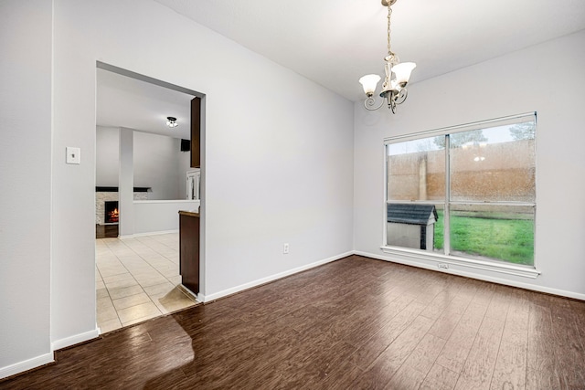 empty room with light wood-type flooring and an inviting chandelier