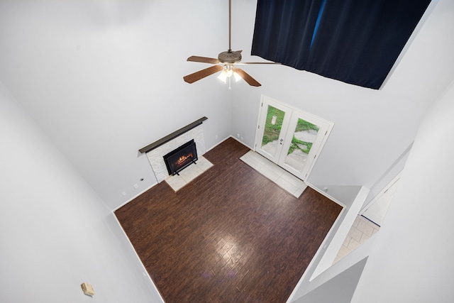 unfurnished living room featuring ceiling fan, french doors, and a towering ceiling