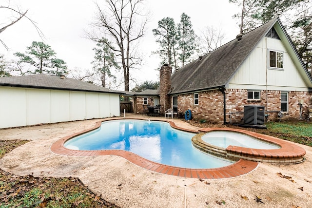 view of pool with an in ground hot tub, cooling unit, and a patio