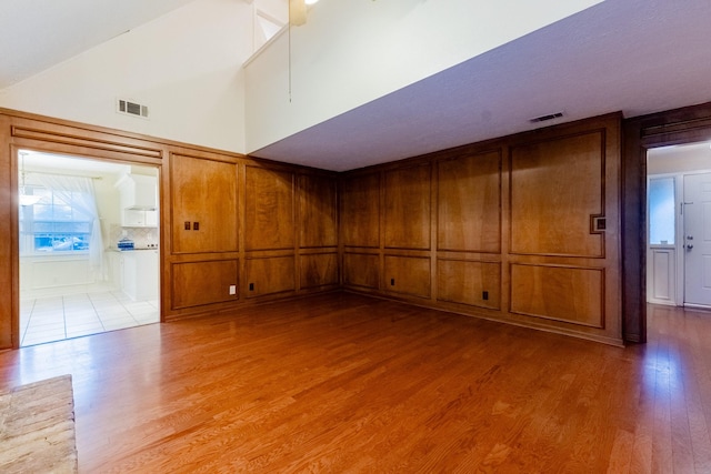 empty room featuring light hardwood / wood-style flooring and high vaulted ceiling