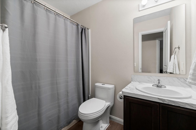 bathroom with a textured ceiling, vanity, toilet, and wood-type flooring