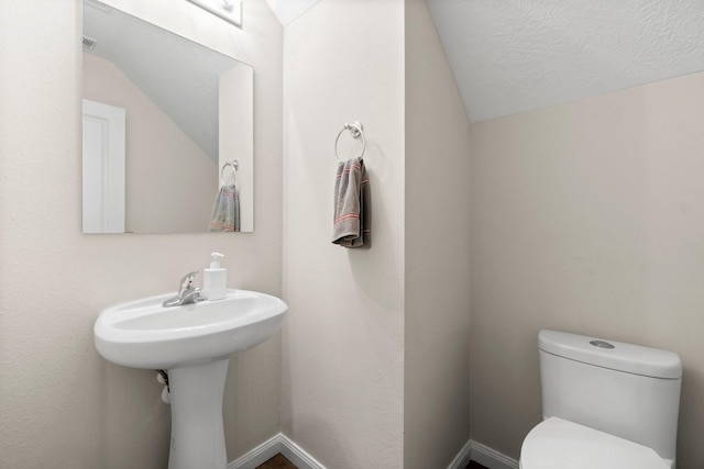 bathroom featuring a textured ceiling and toilet