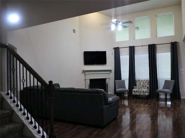 living room featuring ceiling fan and dark hardwood / wood-style flooring