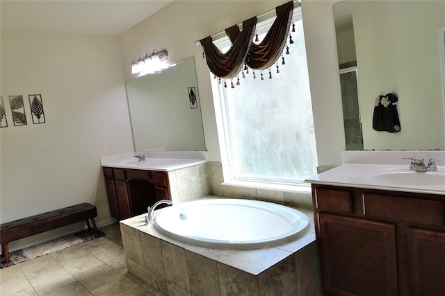 bathroom with tile patterned floors, vanity, and tiled tub