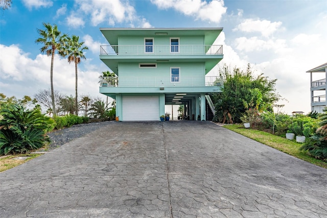 view of front facade with driveway, a garage, a balcony, and a carport