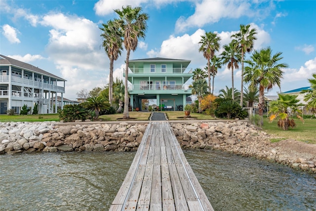 dock area with a balcony and a water view