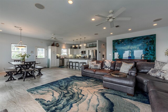 living room with ceiling fan and sink