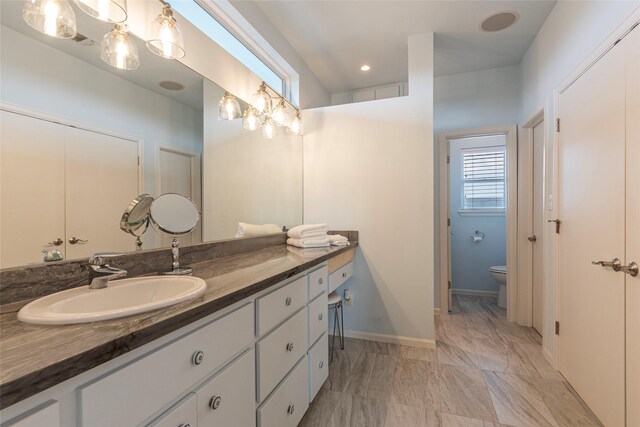 full bath featuring baseboards, marble finish floor, toilet, and vanity