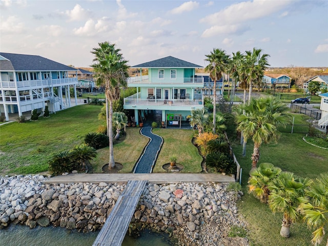 rear view of property with a balcony and a water view