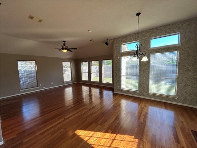 interior space featuring ceiling fan with notable chandelier and dark wood-type flooring