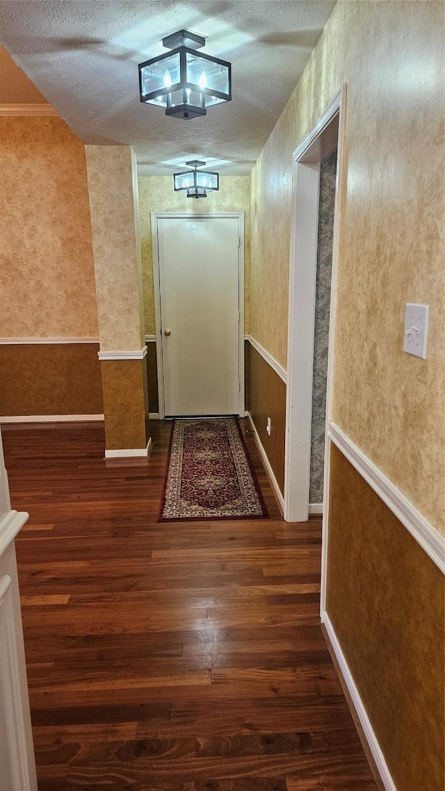 hall with dark hardwood / wood-style flooring and a textured ceiling