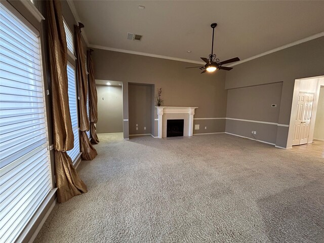 unfurnished living room featuring light colored carpet, ornamental molding, and ceiling fan